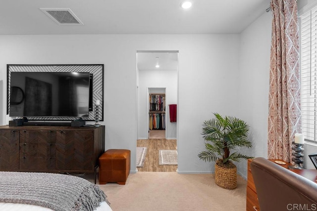 bedroom with a walk in closet and carpet flooring