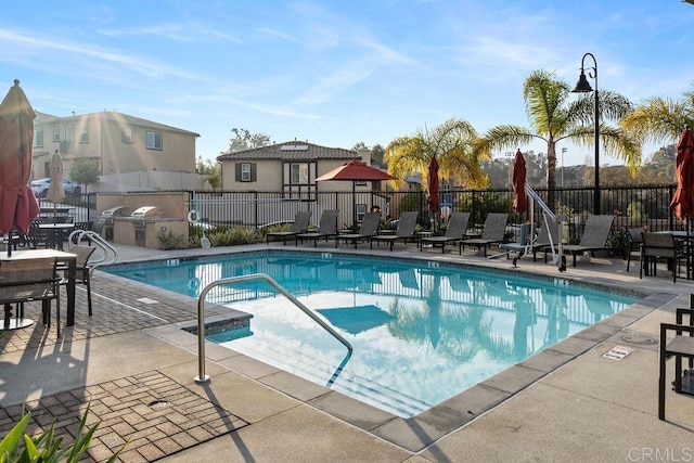 view of pool with area for grilling and a patio