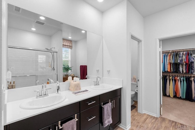 bathroom with vanity, an enclosed shower, hardwood / wood-style floors, and toilet