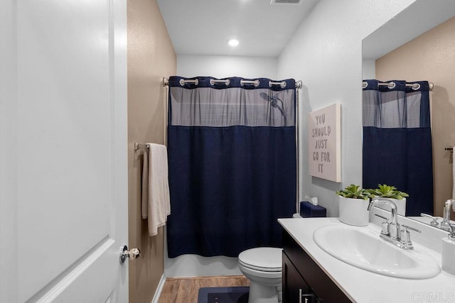 bathroom featuring vanity, hardwood / wood-style floors, curtained shower, and toilet