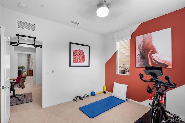 exercise room featuring visible vents, light carpet, and baseboards