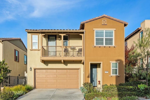 view of front of home featuring concrete driveway, a balcony, an attached garage, fence, and stucco siding