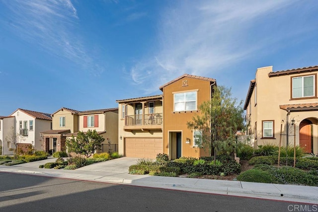 view of front of home featuring an attached garage, a tile roof, driveway, a residential view, and stucco siding