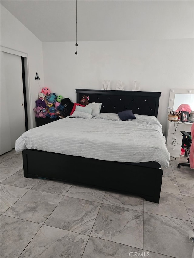 bedroom with lofted ceiling and a closet