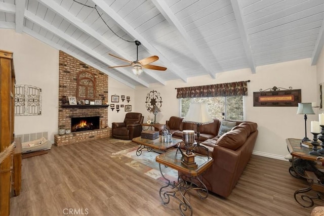 living room with a brick fireplace, vaulted ceiling with beams, hardwood / wood-style floors, and ceiling fan