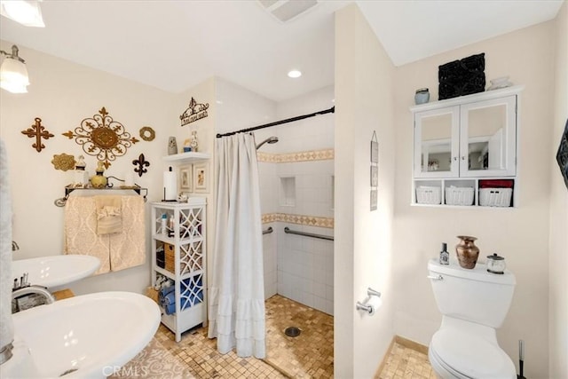 bathroom featuring toilet, sink, and a shower with shower curtain