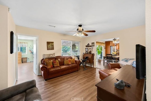 living room featuring light hardwood / wood-style floors and ceiling fan