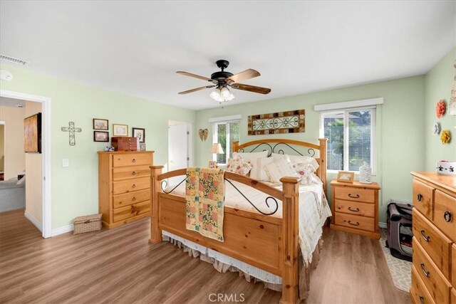 bedroom with light wood finished floors, multiple windows, and visible vents