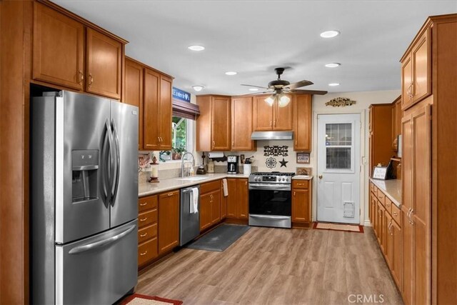 kitchen with ceiling fan, appliances with stainless steel finishes, light hardwood / wood-style floors, and sink