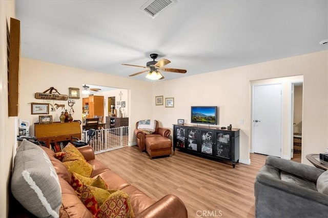 living room featuring light hardwood / wood-style floors and ceiling fan