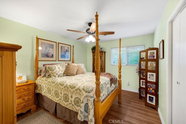 bedroom with a ceiling fan, a closet, baseboards, and wood finished floors