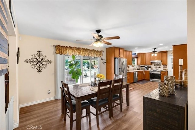 dining area with wood-type flooring and ceiling fan