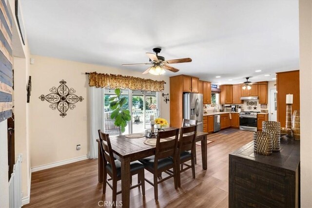 dining space with ceiling fan, baseboards, wood finished floors, and recessed lighting