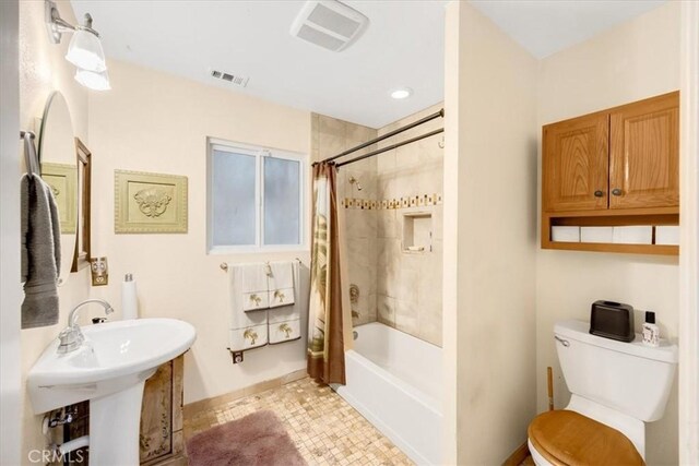 full bathroom featuring sink, shower / tub combo, and toilet