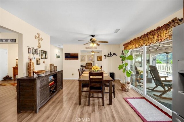 dining space with ceiling fan, light wood finished floors, visible vents, and baseboards