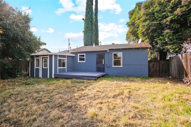 rear view of house featuring a yard and a deck