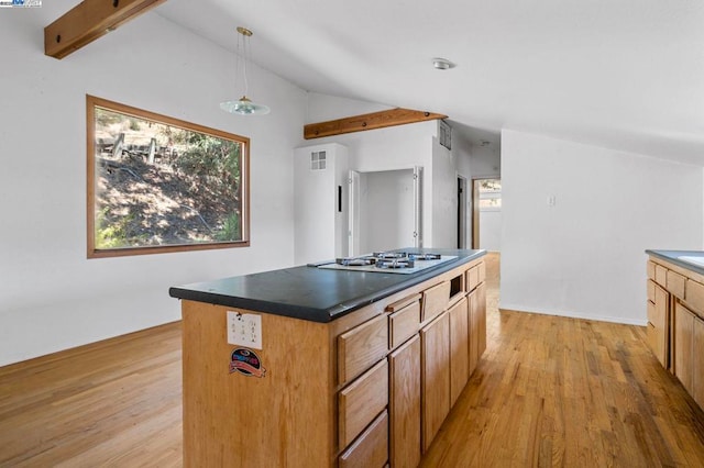 kitchen featuring stainless steel gas cooktop, vaulted ceiling, a kitchen island, pendant lighting, and light hardwood / wood-style floors