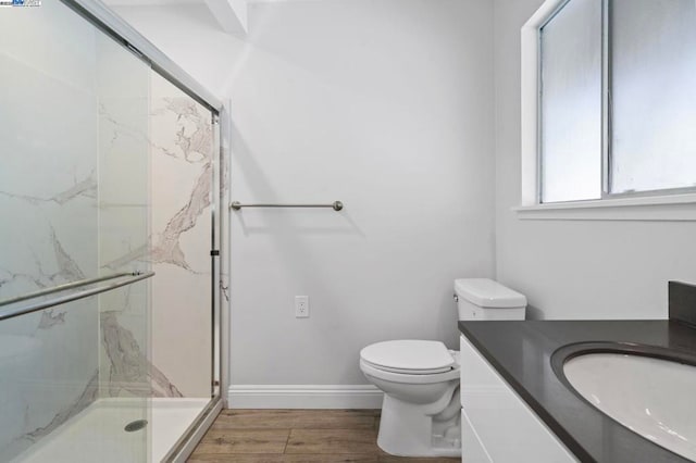 bathroom with vanity, toilet, hardwood / wood-style floors, and a shower with shower door