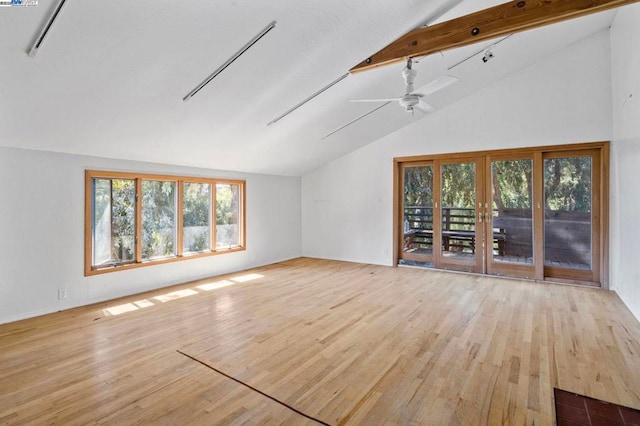 unfurnished living room with vaulted ceiling with beams, light hardwood / wood-style flooring, french doors, and ceiling fan