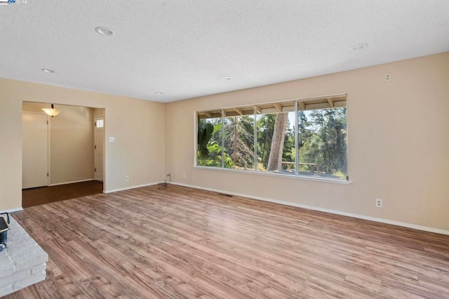 empty room featuring hardwood / wood-style flooring and a textured ceiling