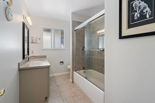 full bathroom featuring vanity, combined bath / shower with glass door, tile patterned floors, and toilet