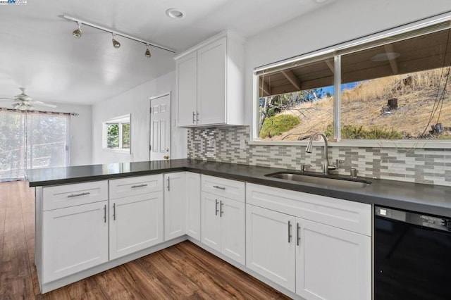 kitchen featuring sink, dishwasher, kitchen peninsula, white cabinets, and backsplash