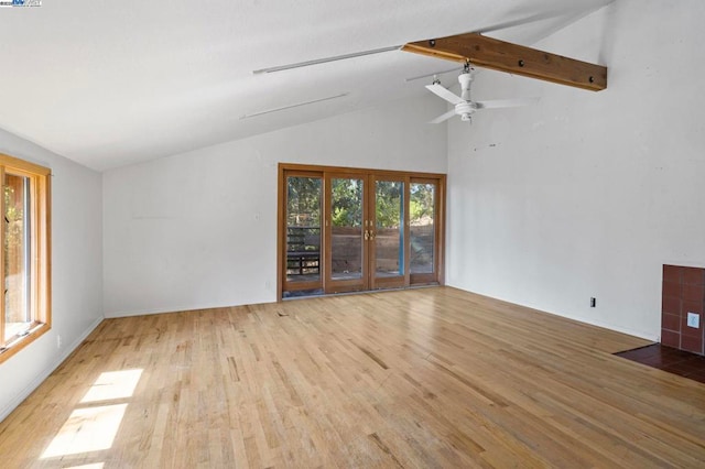 unfurnished living room with beamed ceiling, ceiling fan, light hardwood / wood-style floors, and french doors