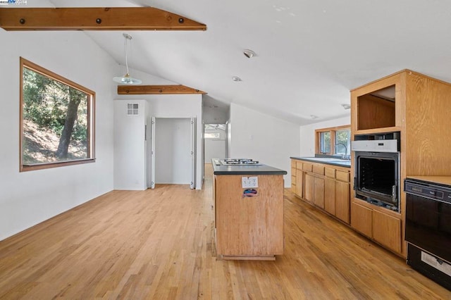 kitchen with gas cooktop, vaulted ceiling with beams, a center island, wall oven, and light hardwood / wood-style floors