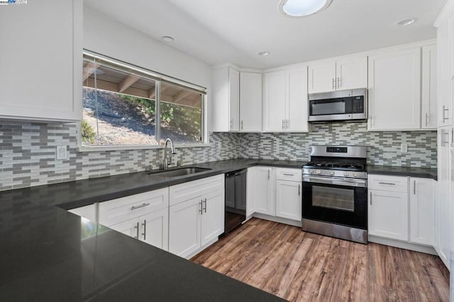 kitchen featuring stainless steel appliances, sink, dark wood-type flooring, and white cabinets