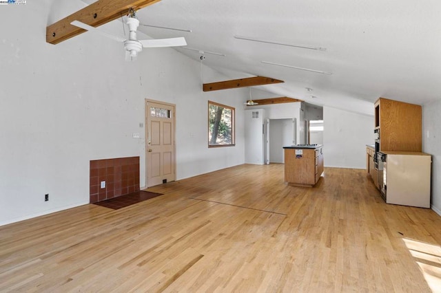 unfurnished living room with lofted ceiling with beams, light hardwood / wood-style floors, and ceiling fan