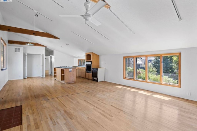 unfurnished living room with lofted ceiling with beams, light hardwood / wood-style floors, and ceiling fan