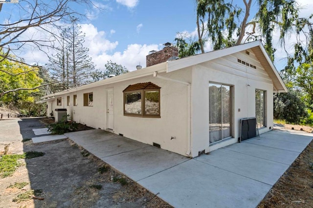 view of side of property with central AC and a patio area