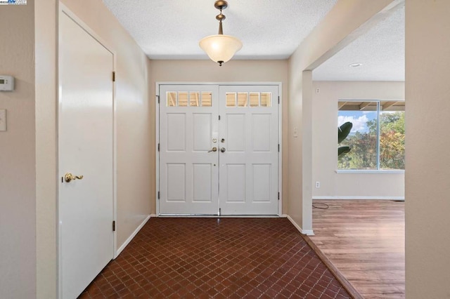 foyer entrance with a textured ceiling