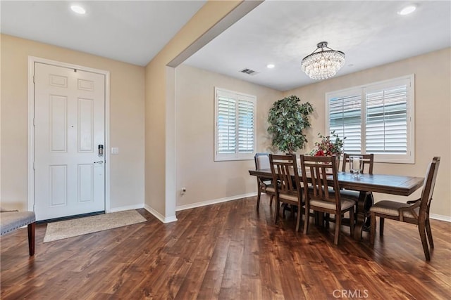 dining room with dark hardwood / wood-style flooring and a notable chandelier