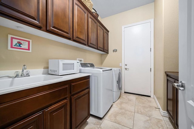 laundry room featuring cabinets, independent washer and dryer, light tile patterned flooring, and sink