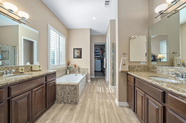 bathroom with vanity, hardwood / wood-style floors, and separate shower and tub