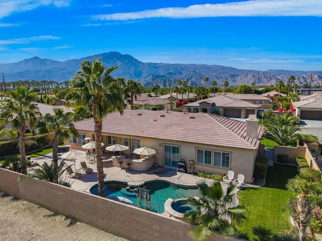 back of house featuring a fenced in pool, a mountain view, and a patio area