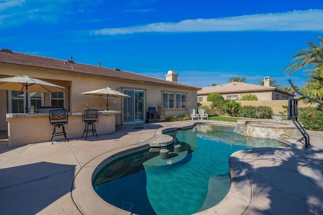 view of pool with an in ground hot tub, an outdoor bar, and a patio