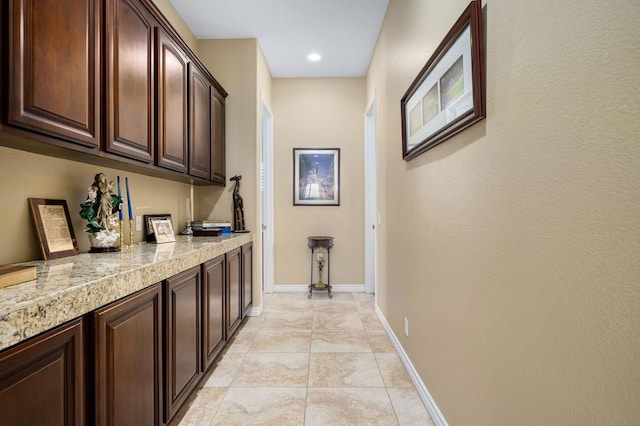 bar featuring light tile patterned floors and dark brown cabinets