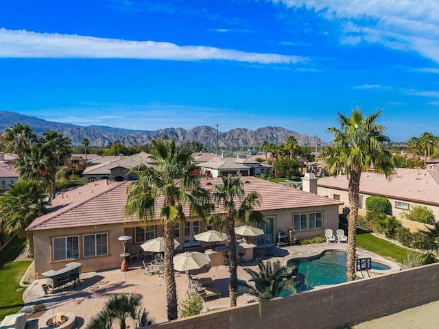 view of swimming pool with a patio, a mountain view, and an outdoor fire pit