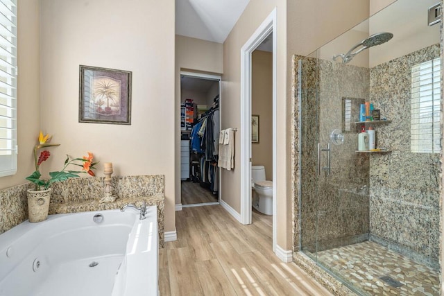 bathroom featuring plus walk in shower, hardwood / wood-style floors, and toilet