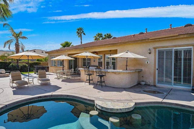 view of pool with a patio area and a bar