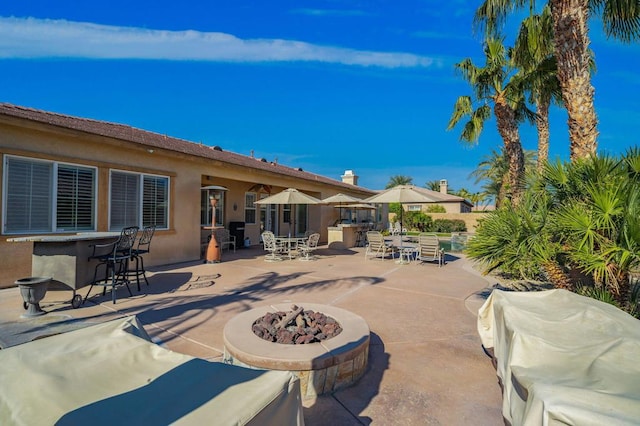 view of patio featuring exterior bar and a fire pit