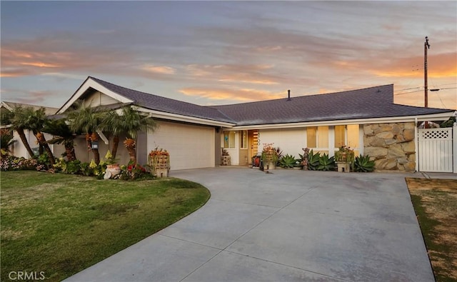 single story home with a garage and a lawn