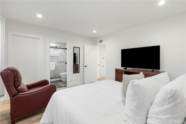 bedroom featuring ensuite bath and light hardwood / wood-style flooring