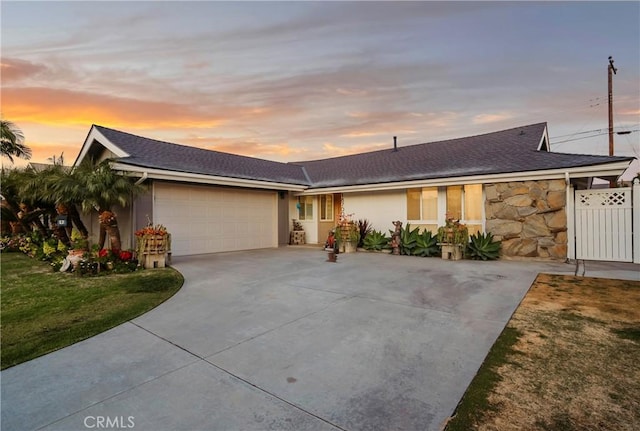 ranch-style house featuring a garage and a lawn