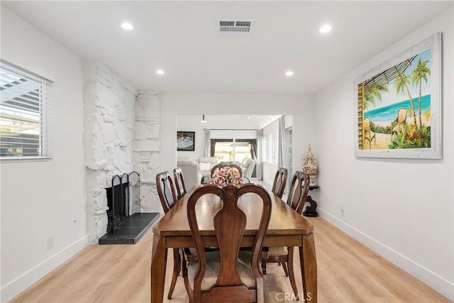 dining room with a fireplace and light hardwood / wood-style flooring