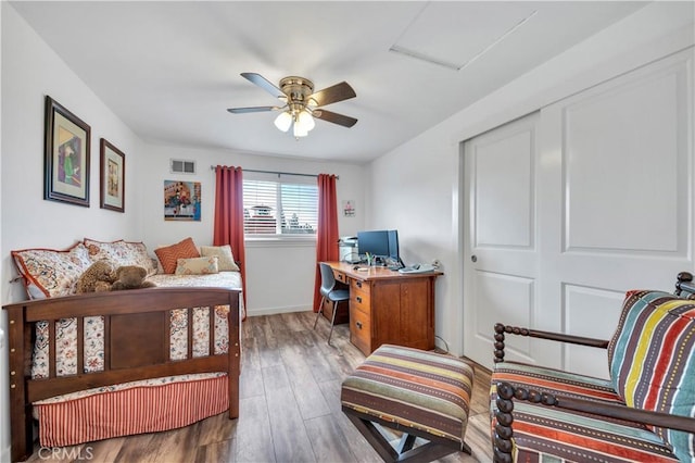 bedroom with hardwood / wood-style floors, ceiling fan, and a closet