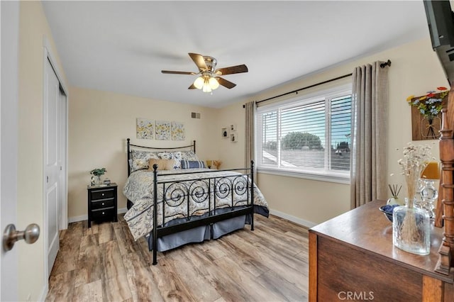 bedroom with ceiling fan, a closet, and light hardwood / wood-style flooring