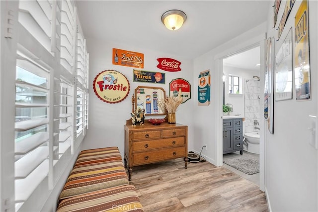 bedroom with ensuite bath and light hardwood / wood-style flooring